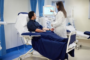 Dialysis patient covered with a blanket talking to a doctor