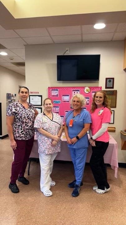 Group of staff poses for sepsis awareness photo in front of their display