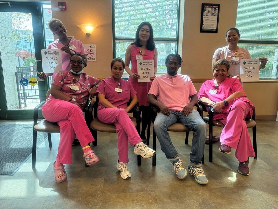 Group of staff poses in pink for sepsis awareness photo